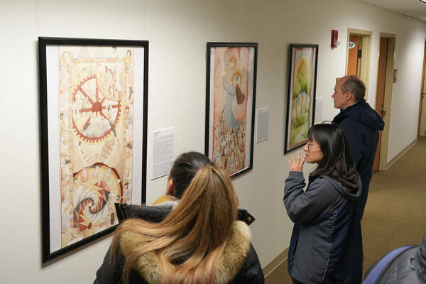 Students and faculty view student artwork at Arts of Dignity Exhibition.