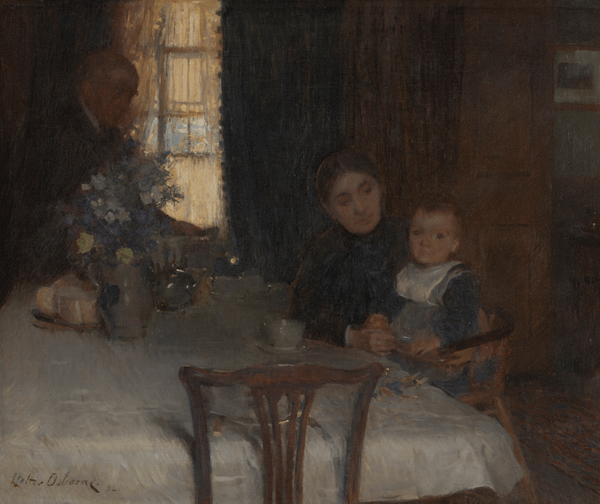 A woman in dark clothing sits at a table with a young child in a high chair. The child holds a piece of fruit. A partially visible figure stands near a window in the background. A vase of flowers and bread sit on the white tablecloth.