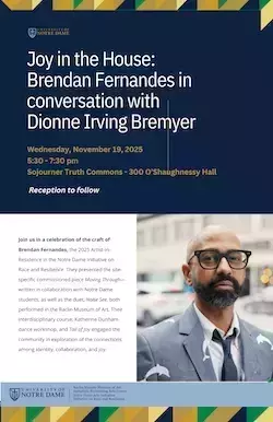 Brendan Fernandes in a gray suit coat with black framed glasses