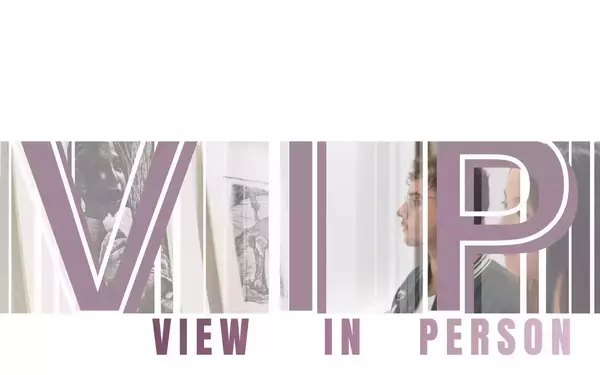 V.I.P. VIEW IN PERSON. A man with glasses in a green jacket views framed art, including a grayscale portrait, at an exhibition.