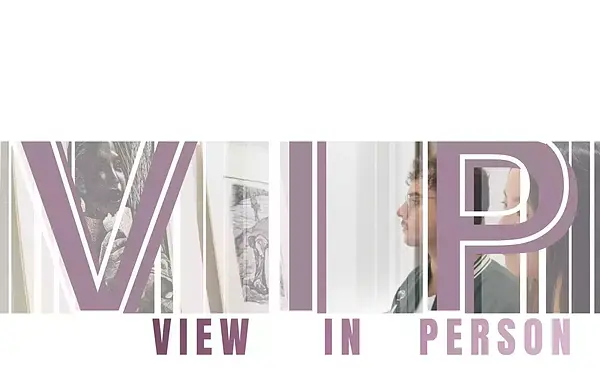 V.I.P. VIEW IN PERSON. A man with glasses in a green jacket views framed art, including a grayscale portrait, at an exhibition.